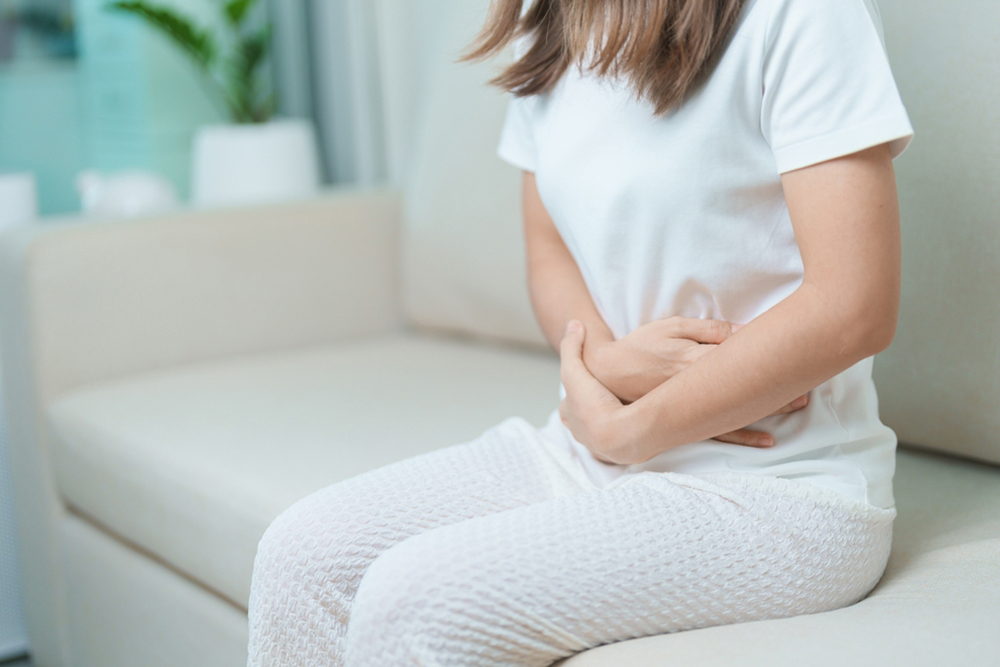 woman having abdomen ache due to Stomach pain, digestion with constipation or Diarrhea from food poisoning, female problem and Endometriosis, Hysterectomy, Stomachache and Menstrual on sofa at home.